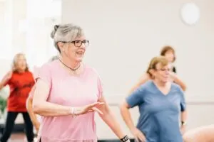 mulher de terceira idade dançando em grupo